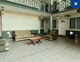 Un salón amplio con sofá, sillón y mesa de centro.