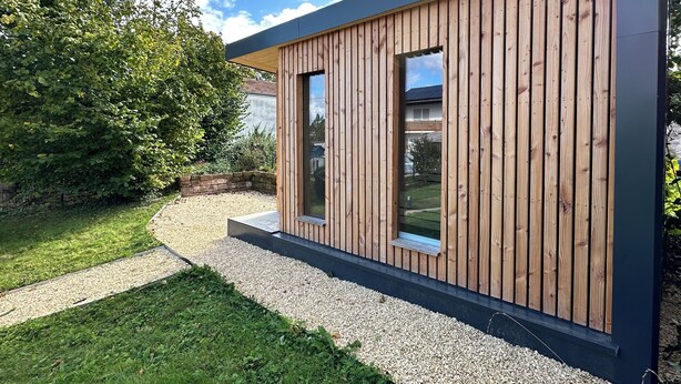 A modern wooden building with a large window and a gravel pathway leading to it. - Wine and forest, cozy vacation home with outdoor sauna and a big garden (Landau in der Pfalz)