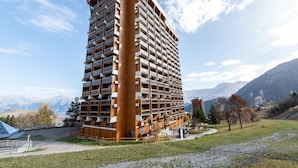 Een hoog hotel met een uniek architectonisch ontwerp, met een opvallend cilindervormig gedeelte en meerdere balkons.