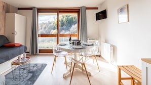 Een moderne kamer met een eettafel, stoelen en een bank.