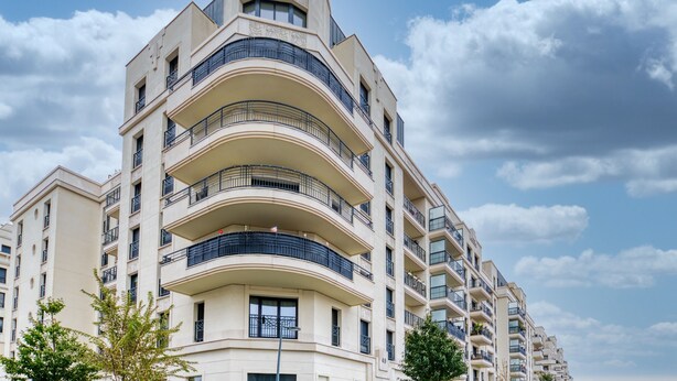 Un edificio residencial de varios pisos con balcones y un diseño arquitectónico curvo.