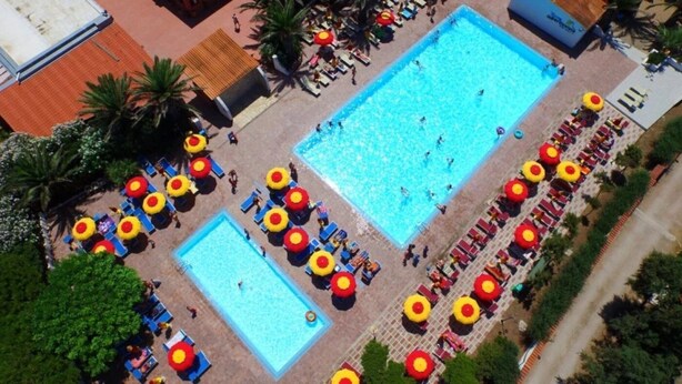 An aerial view of a swimming pool area with multiple pools, sun loungers, and umbrellas. - ZEcamping 4 étoiles pataugeoire locatif TV clim 67m2 (Alghero)