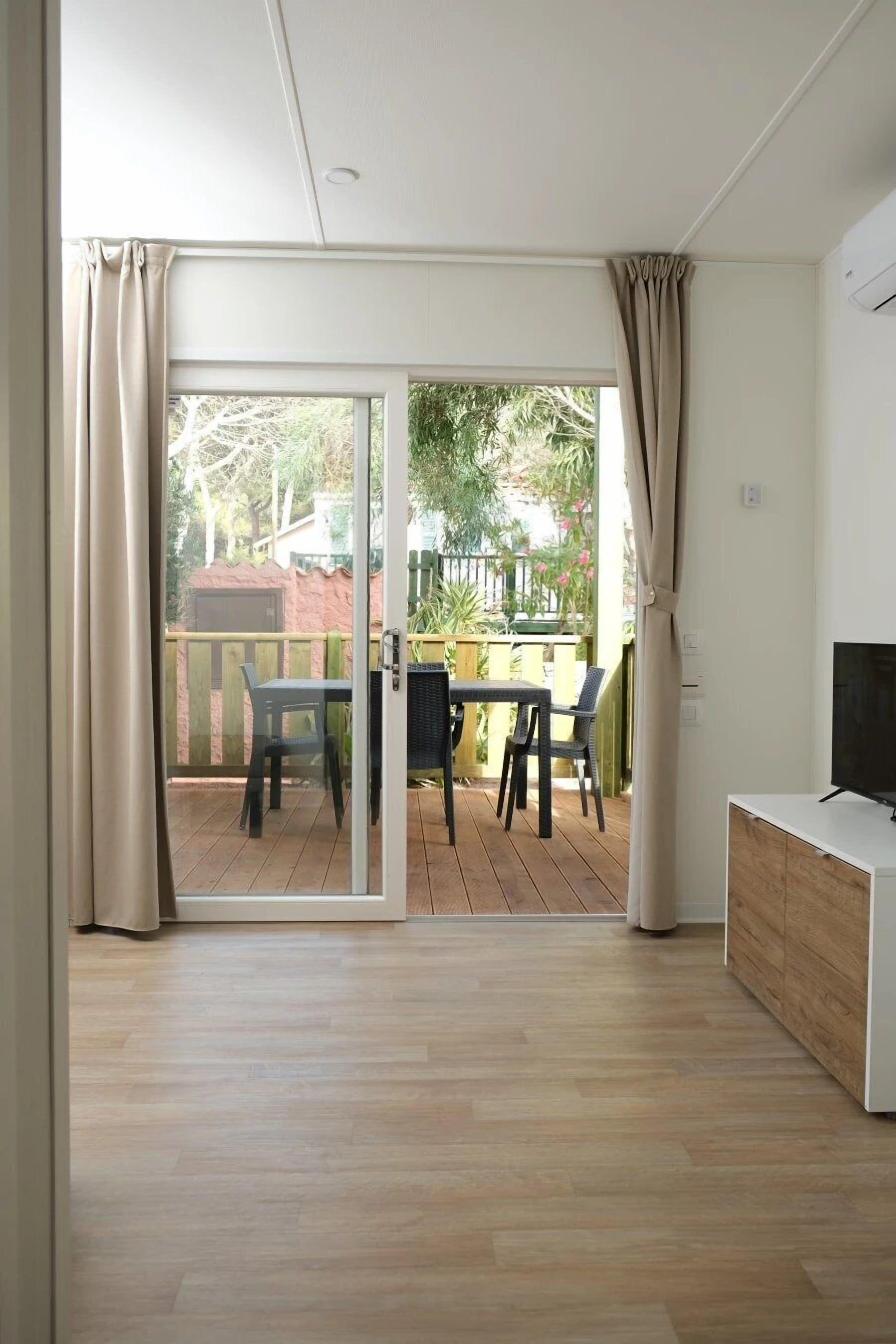 Quarto com porta de vidro deslizante que dá para uma varanda externa.