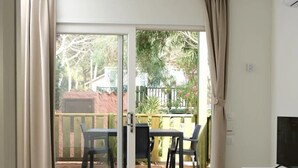 A room with a sliding glass door leading to an outdoor patio area. - ZEcamping 4 étoiles pataugeoire locatif TV clim 67m2 (Alghero)