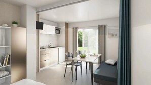 Un espace de vie moderne et compact comprenant un coin cuisine, un espace repas et un lit.