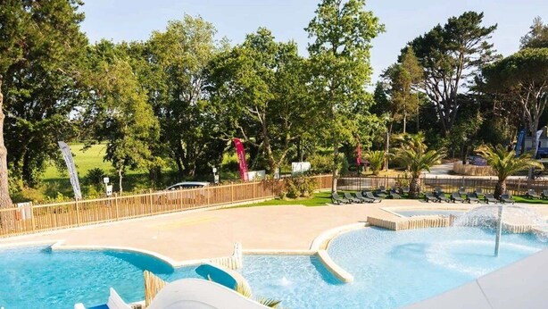 A water park with multiple slides and a pool area surrounded by trees.