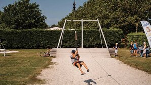 Une balançoire dans un parc, sous un ciel dégagé.