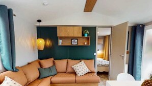 Ein modernes Wohnzimmer mit einer Couch, einer Wandregal und einer Tür zu einem anderen Raum.