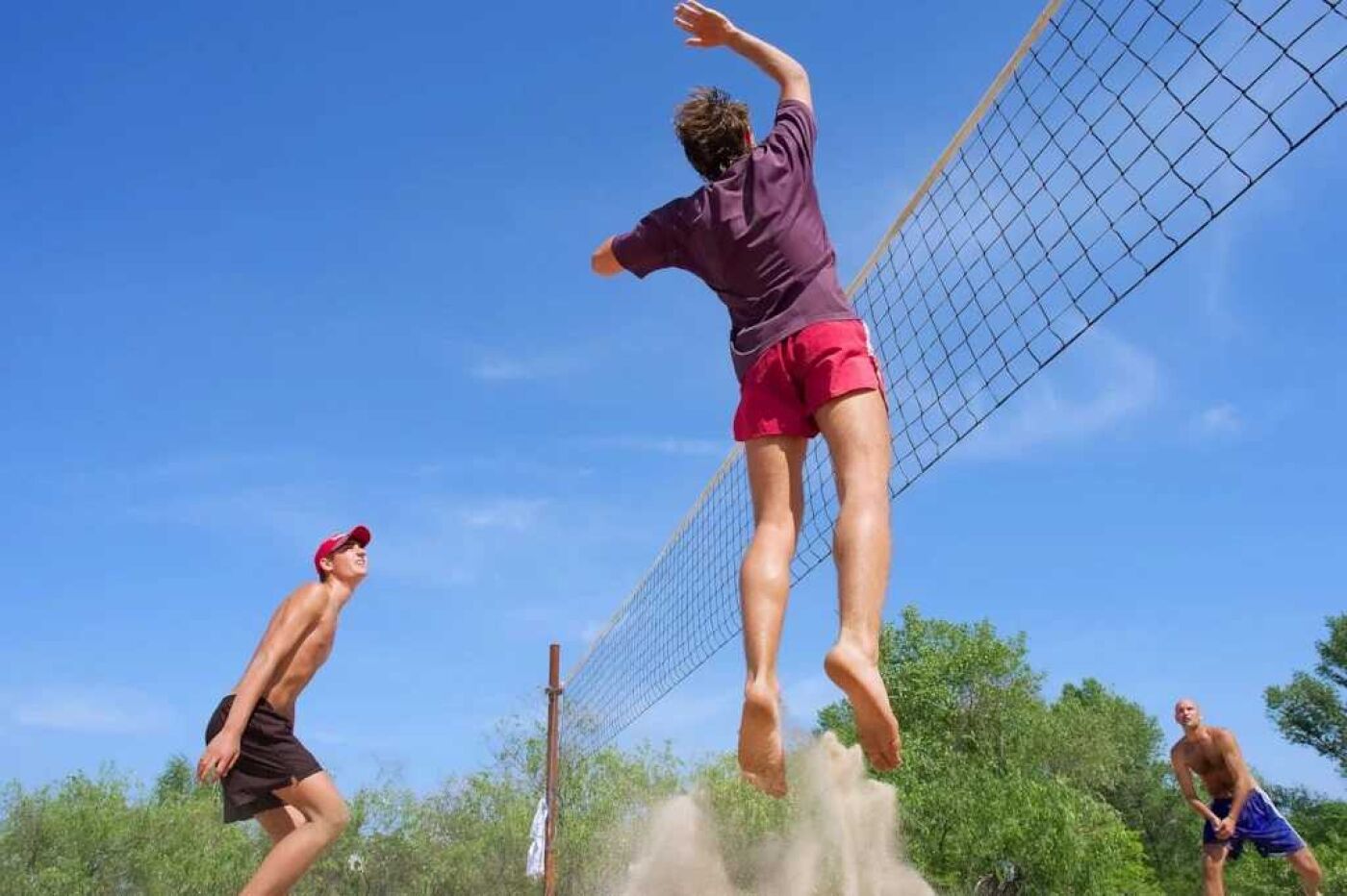 Een volleybalwedstrijd bezig, spelers in sportkleding.