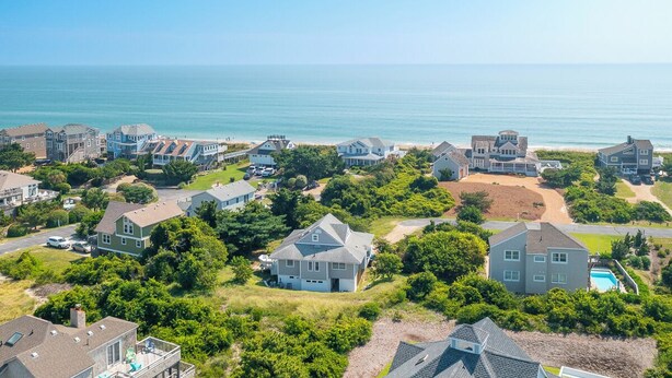 A coastal residential area with houses, a beach, and a clear view of the ocean. - Sun Realty warm Duck NC vacation rental, just a short walk to the beach (Duck)