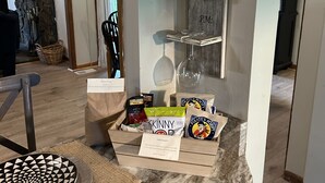A kitchen counter with a tray of snacks, a coffee maker, and a mug shelf.