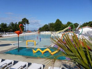 Une piscine avec un toboggan et une sculpture de flamant rose.