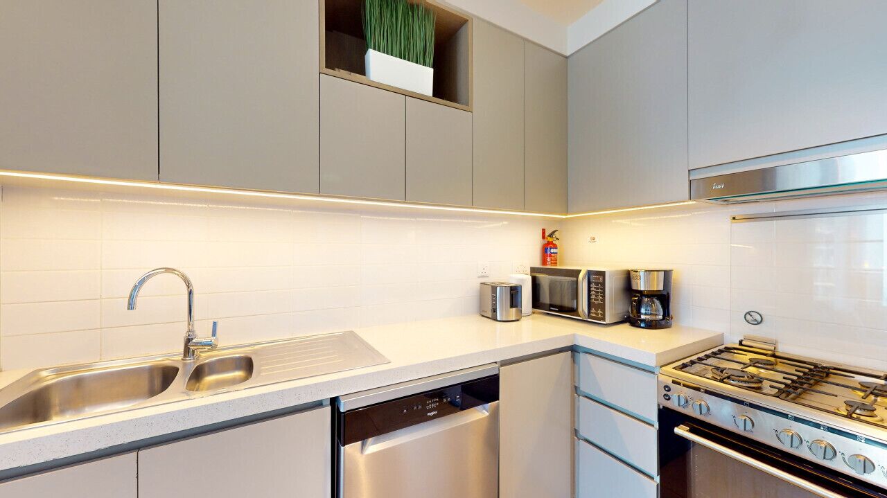 A modern kitchen with stainless steel appliances, a dishwasher, and a built-in oven.