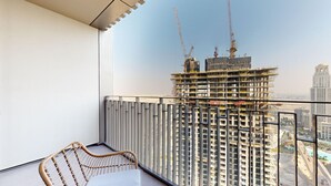 Un balcón con vista a una obra en construcción y un rascacielos al fondo.