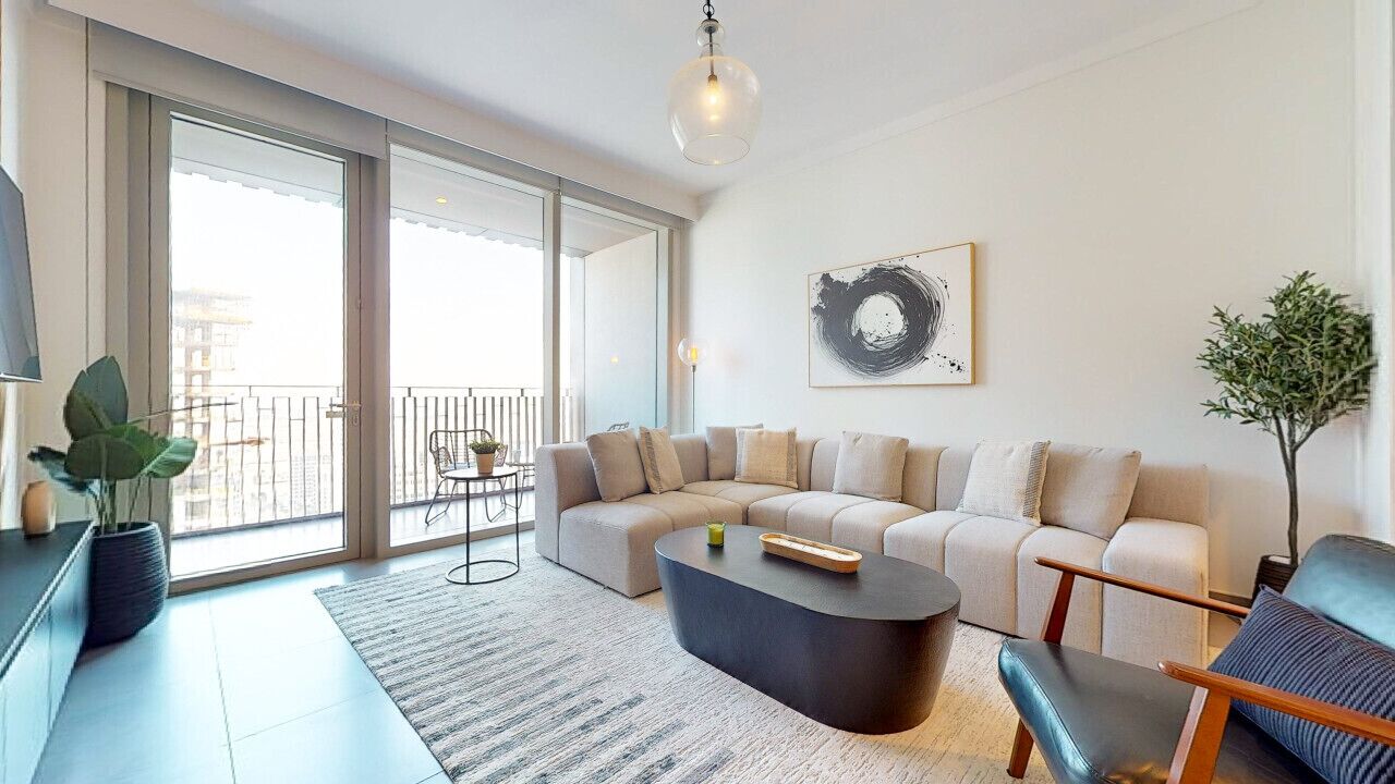 Ein modernes Wohnzimmer mit einer Eckcouch, einem Couchtisch und Blick auf den Balkon.