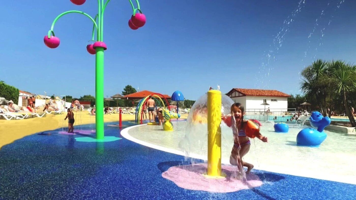 A water park with a colorful play area, including a water slide and various water features.