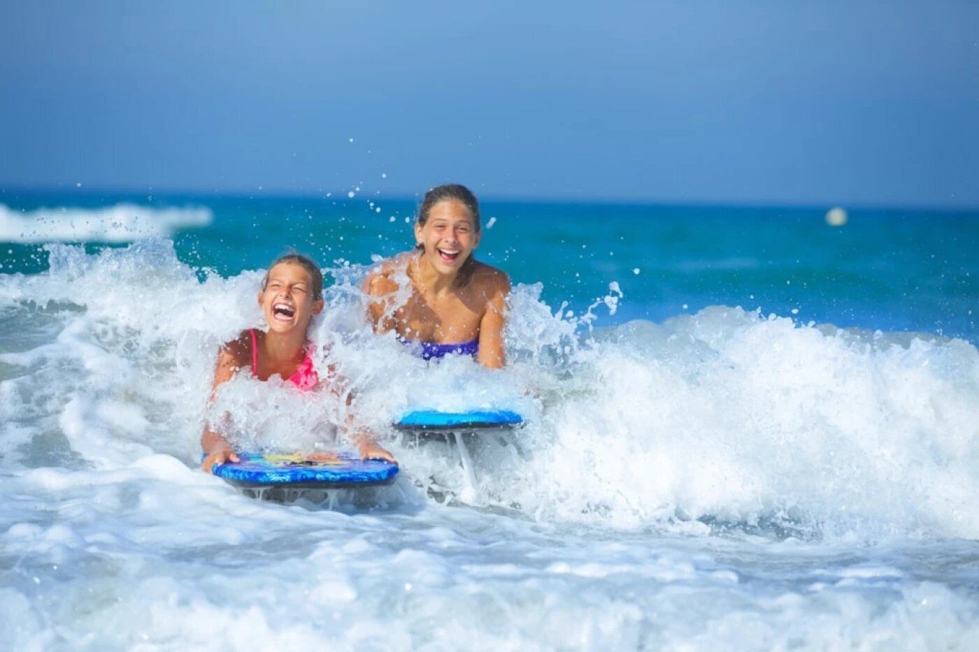 Two individuals on a surfboard in the ocean with waves.