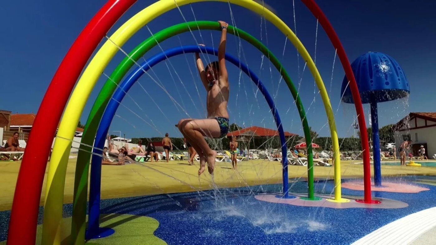 Un área de juegos acuáticos con múltiples arcos y una fuente de agua.