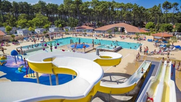 A water park with multiple slides and pools, surrounded by buildings and trees. - ZEcamping 4* animé 500m plage espace aquatique locatif TV LV clim 36m2 (Seignosse)