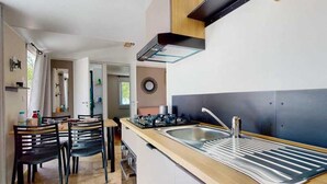 Une cuisine moderne dotée d’une cuisinière intégrée, d’un évier et d’un plan de travail en bois.