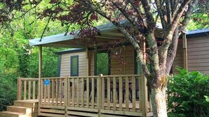 A small cabin with a wooden deck and a covered porch. - ZEcamping 4 étoiles piscine couverte toboggans locatif 28m2 4 pers (Névez)