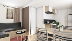 A modern, compact living space with a sofa, dining table, and kitchenette. - ZEcamping 4 étoiles piscine couverte toboggans locatif 28m2 4 pers (Névez)