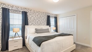 A bedroom with a bed, nightstands, a lamp, and a window with curtains. - Beautiful Storey Lake Retreat Minutes From Disney (Kissimmee)