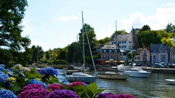 A harbor with boats, colorful flowers in the foreground, and buildings in the background. - ZEcamping 4* piscine couverte toboggans pet friendly locatif 28m2 (Névez)