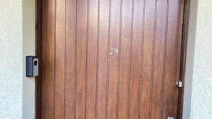 Una porta in legno con il numero 29, un campanello e una maniglia.
