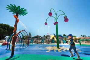 Children can play and enjoy the water in this outdoor play area featuring a fountain and water slide.