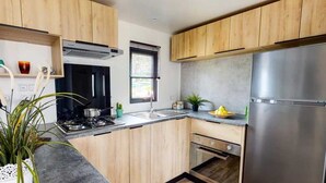Une cuisine moderne avec des meubles en bois, un réfrigérateur en acier inoxydable et un four encastré.
