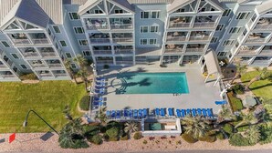 Um hotel com vários andares, piscina no terraço e área de estar ao ar livre.