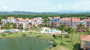 Un resort con varias edificaciones, una piscina y un lago.