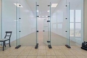A modern interior with glass partitions, a chair, and a sign with rules.