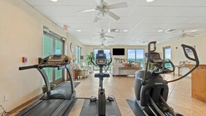 Een fitnessruimte met loopbanden, een elliptische machine en een hometrainer.