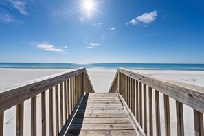 A wooden boardwalk leading to a beach with a clear sky and sun shining. - ⛱️Charming Beach Front House | Private Boardwalk | Far Reach II⛱️ (Gulf Shores)