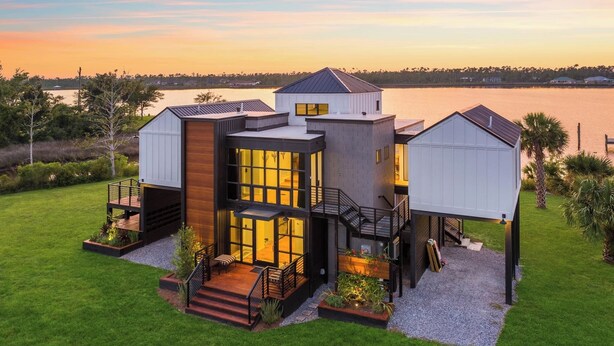 A modern house with a large deck, a covered patio, and a view of the water. - A Luxury Bayfront Retreat with a Resort-Style Pool & Private Dock (Panama City)