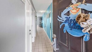 Pasillo de hotel con un letrero azul que dice 'Hello' y un letrero de prohibido fumar.