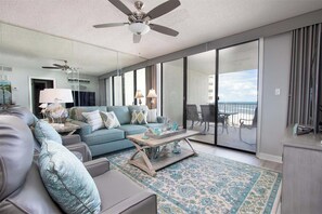 Un salón moderno con sofá, mesa de centro y balcón con vistas.