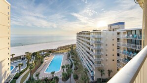 Un hotel con piscina, vistas a la playa y varios balcones.