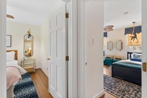 A bedroom with a bed, bedside table, and a mirror. - 4BR, Best Location, Pool, Hot tub, Game Room (raleigh)