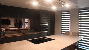 A modern kitchen with a large island, dark cabinetry, and a built-in oven. - Luxury 2 bedroom-Fully Accessible ground floor property. Norfolk, Attleborough. (Attleborough)