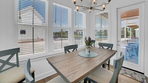 A dining area with a wooden table, chairs, and a chandelier.