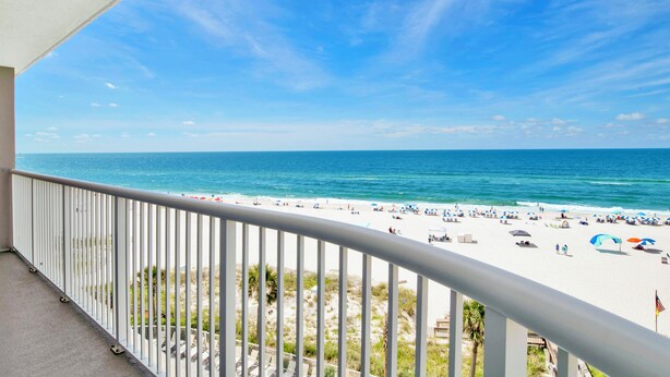 Ein Balkon mit Blick auf Strand und Meer.