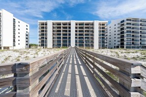 A wooden boardwalk leading to a modern multi-story building with balconies. - ⛱️Wind Drift 501E | Water Front with Gorgeous Views | Walk to Beach⛱️ (Orange Beach)