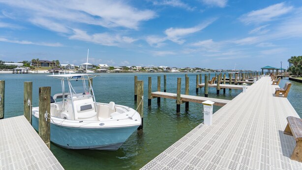 A dock with a boat, wooden benches, and a pier extending into calm water. - ⭐Wind Drift 702E | Gulf Front with Gorgeous Views | Walk to Beach⭐ (Orange Beach)