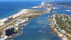 An aerial view of a coastal city with a marina, a bridge, and a beach. - ⭐Wind Drift 702E | Gulf Front with Gorgeous Views | Walk to Beach⭐ (Orange Beach)