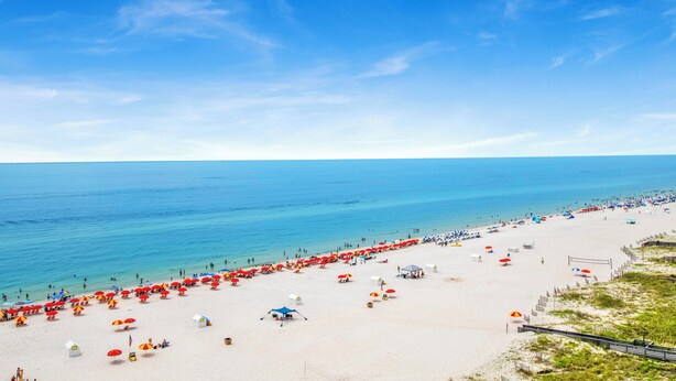 A beach with rows of umbrellas and beachgoers. - 🌊Windward Pointe 1002 | Gulf Front | Awesome Amenities🌊 (Orange Beach)