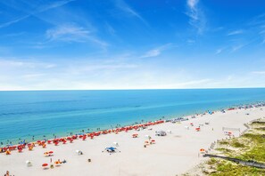 A beach with rows of umbrellas and beachgoers. - 🌊Windward Pointe 1002 | Gulf Front | Awesome Amenities🌊 (Orange Beach)