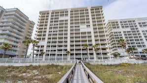 A multi-story hotel with a central courtyard, balconies, and a pathway leading to the entrance. - 🌊Windward Pointe 1002 | Gulf Front | Awesome Amenities🌊 (Orange Beach)